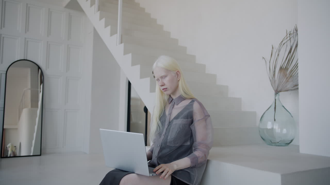 Woman working on laptop in a modern home