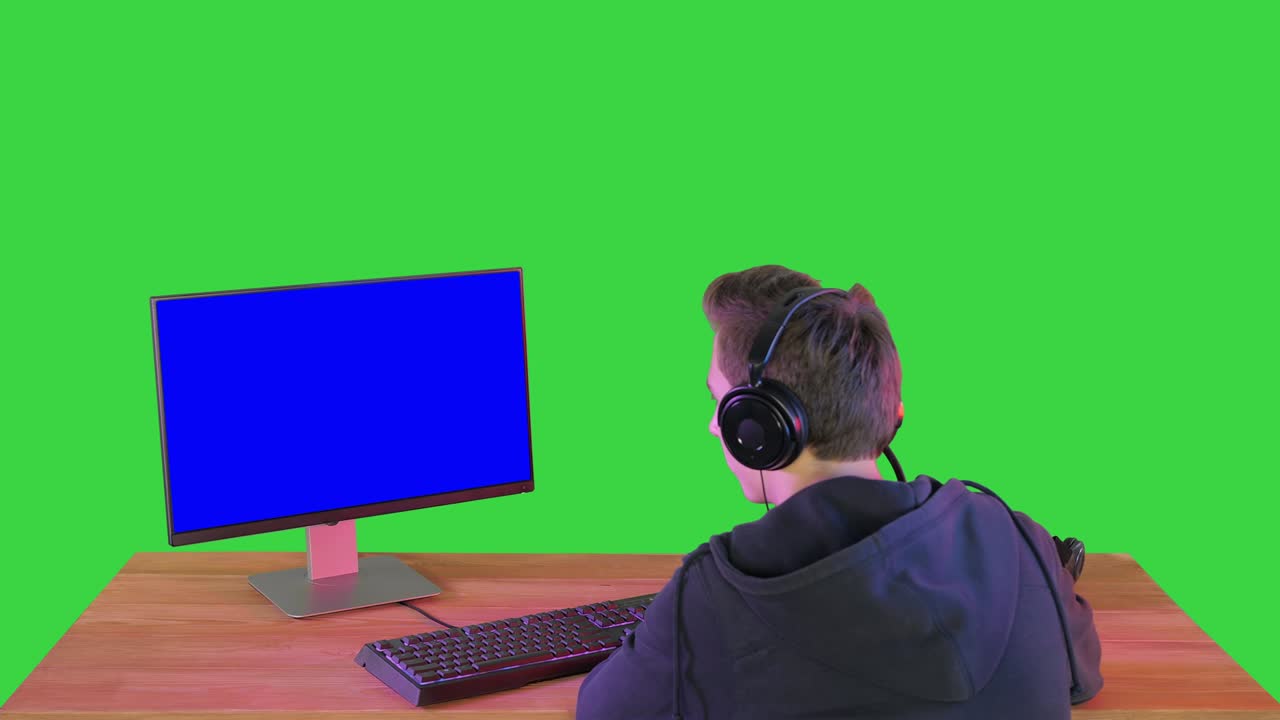 jugador profesional mirando su computadora personal en una pantalla verde, clave de croma