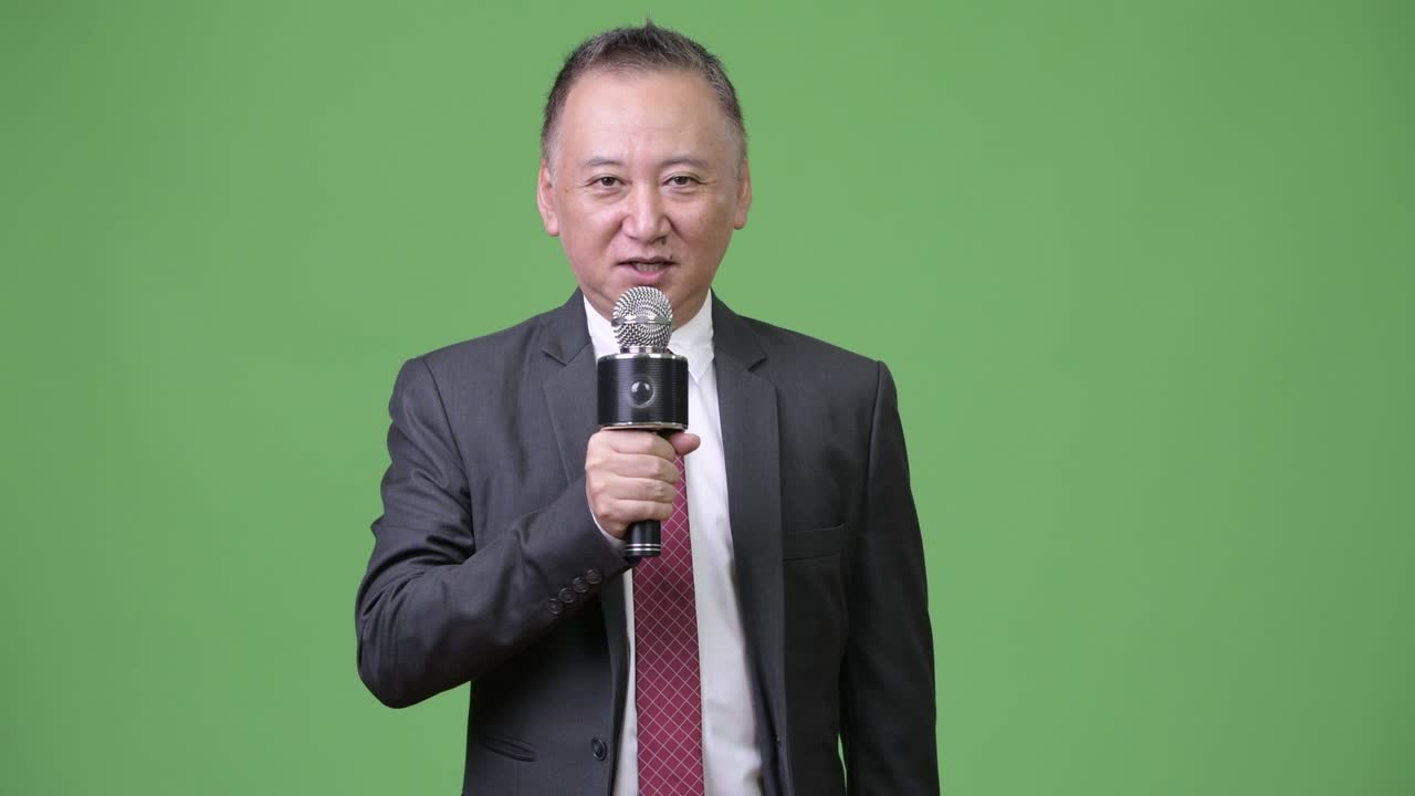 Mature Japanese businessman using microphone