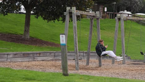 una chica disfrutando del swing en un parque.