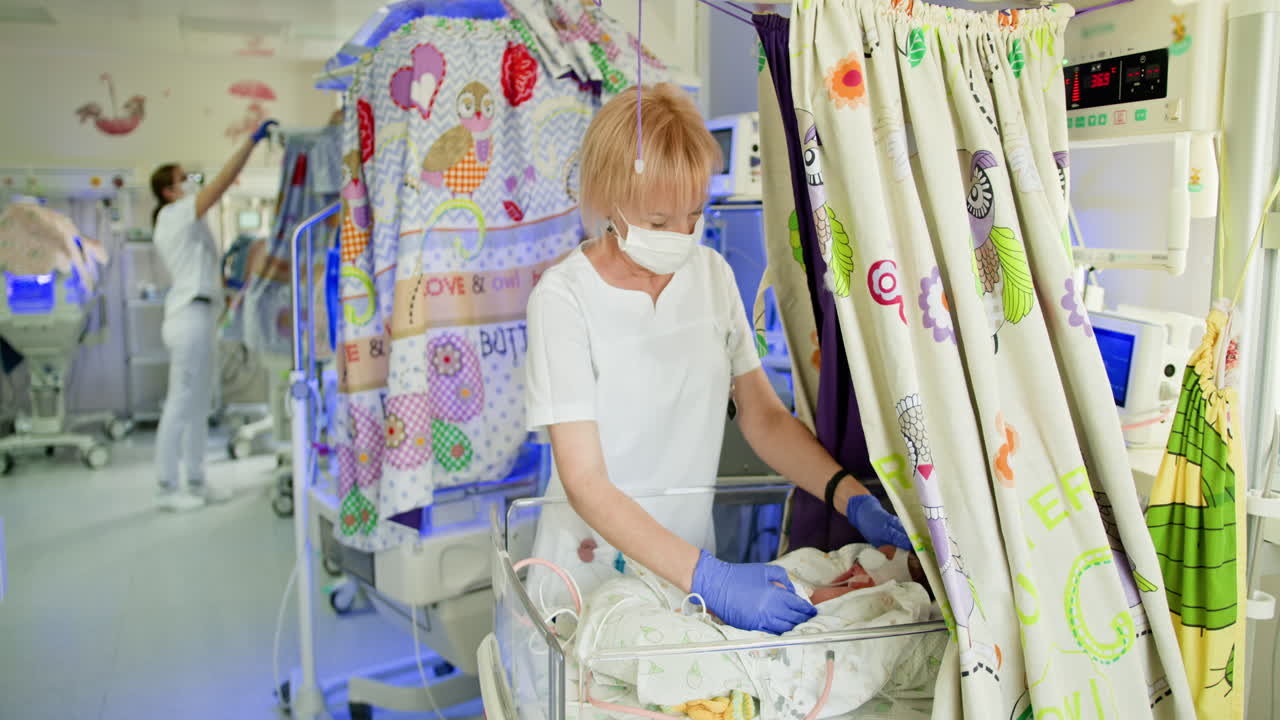 enfermera que cuida a un recién nacido en la guardería del hospital