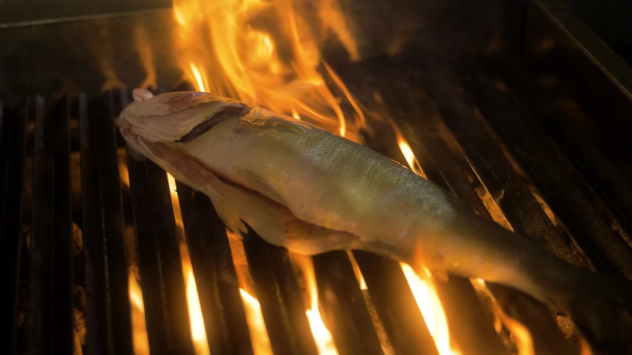 Il pesce viene grigliato mentre è circondato dalle fiamme.