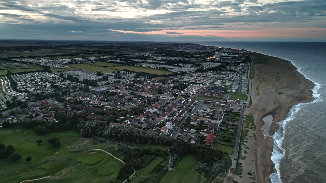 sea testigo de skegness en la puesta de sol dorada a través de imágenes de drones: el parque de vacaciones, el mar, la playa y las caravanas crean una escena pintoresca