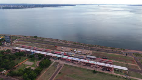 aerial establishing fly sambadrome, dance venue in encarnación, paraguay, border city with misiones, argentina, waterfront landscape