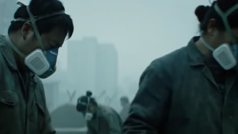 a group of workers wearing protective masks engages in a task amidst a foggy, possibly industrial environment, highlighting themes of safety and teamwork