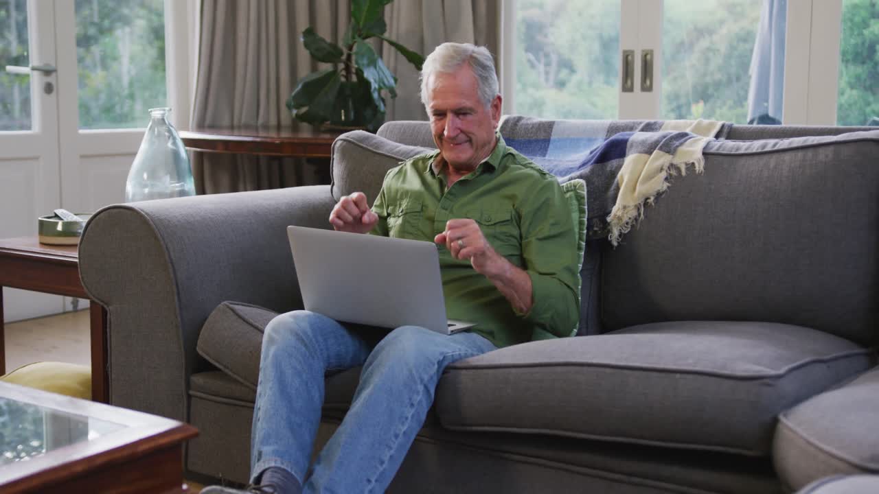 Senior Caucasian man happy, putting his hands in the air at home