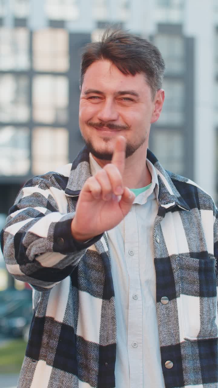 hombre caucásico molesto reaccionando a una desagradable idea horrible sacudiendo el dedo a la cámara en la calle urbana de la ciudad