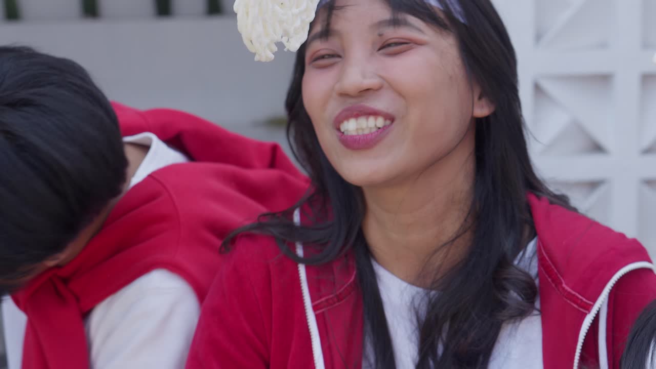 인도네시아 독립기념일을 축하하기 위해 열리는 롬바 마칸 케루푸크 (lomba makan kerupuk) 라는 크래커를 먹는 대회에 참가하는 행복한 아시아 젊은이들