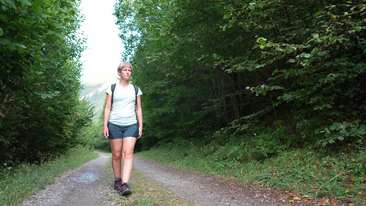Eine Frau wandert auf einem Waldweg