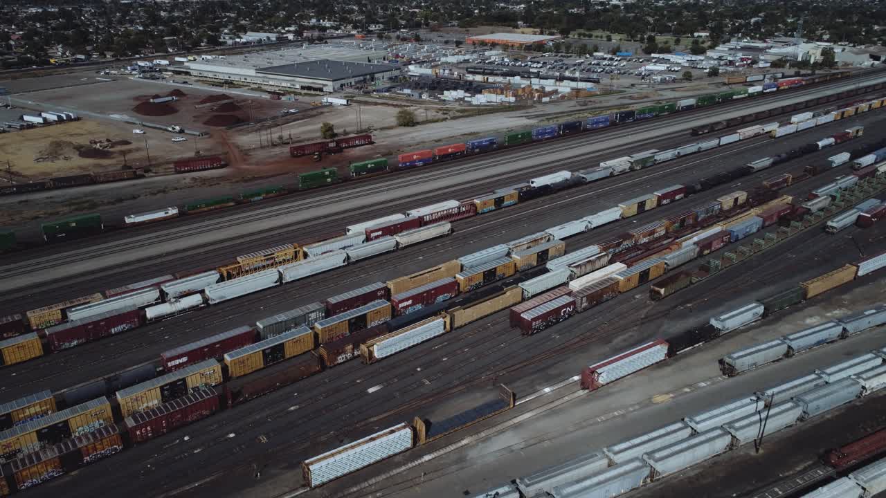 Aerial drone shot of a busy rail yard with a train leaving. 4K, UHD.