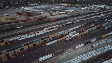 aerial drone shot of a busy rail yard with a train leaving. 4k, uhd.