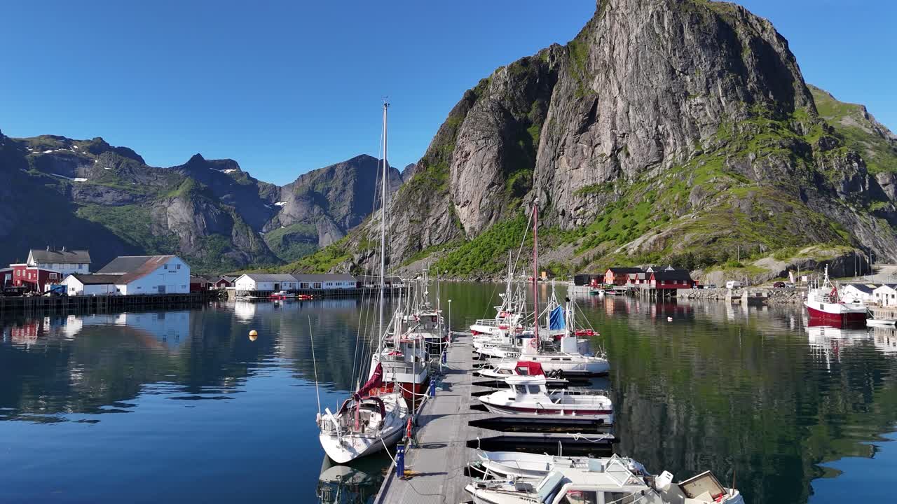 Aerial footage captured by drone, flying over boats and yachts docked at the pier in Hamnøy, Lofoten Islands, Norway