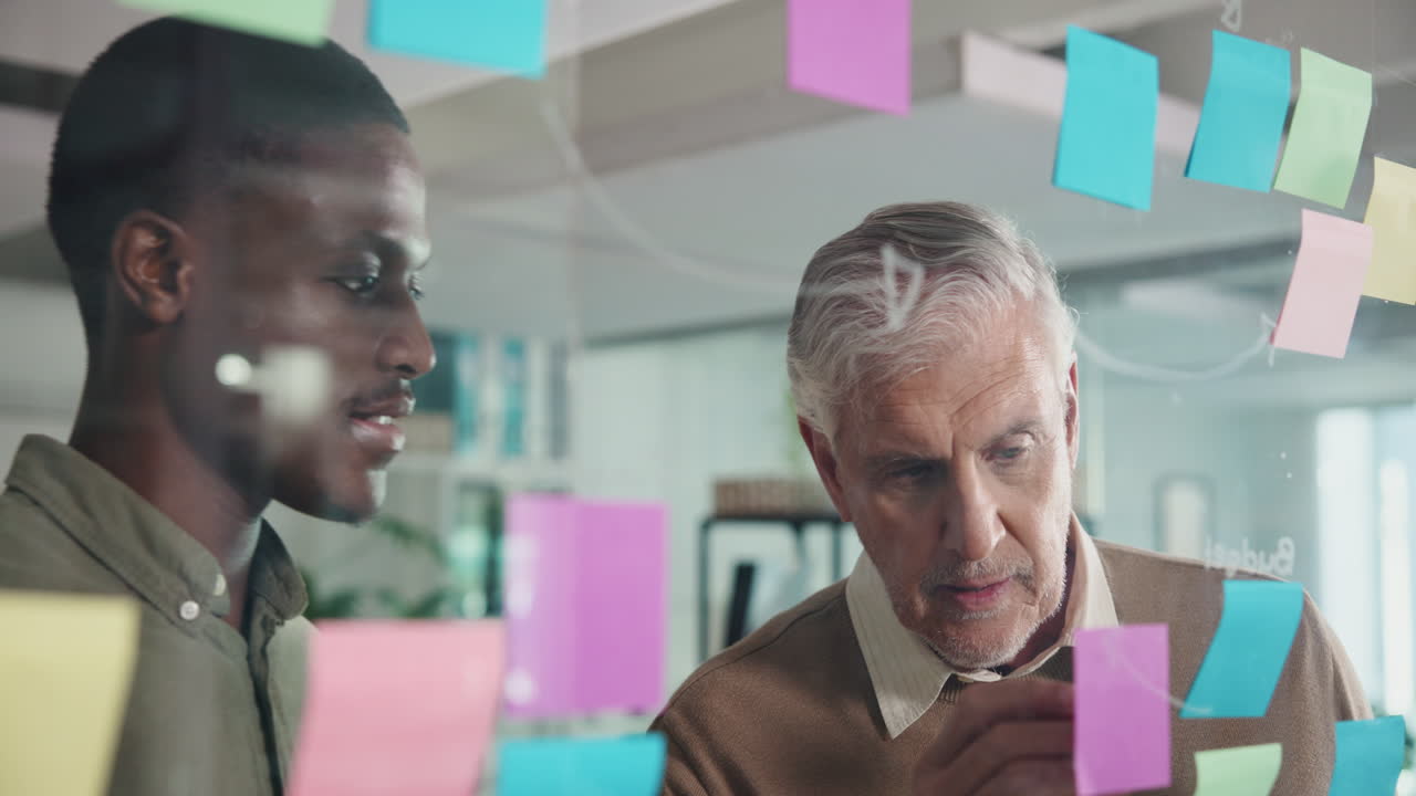 Two businessmen brainstorming ideas using sticky notes