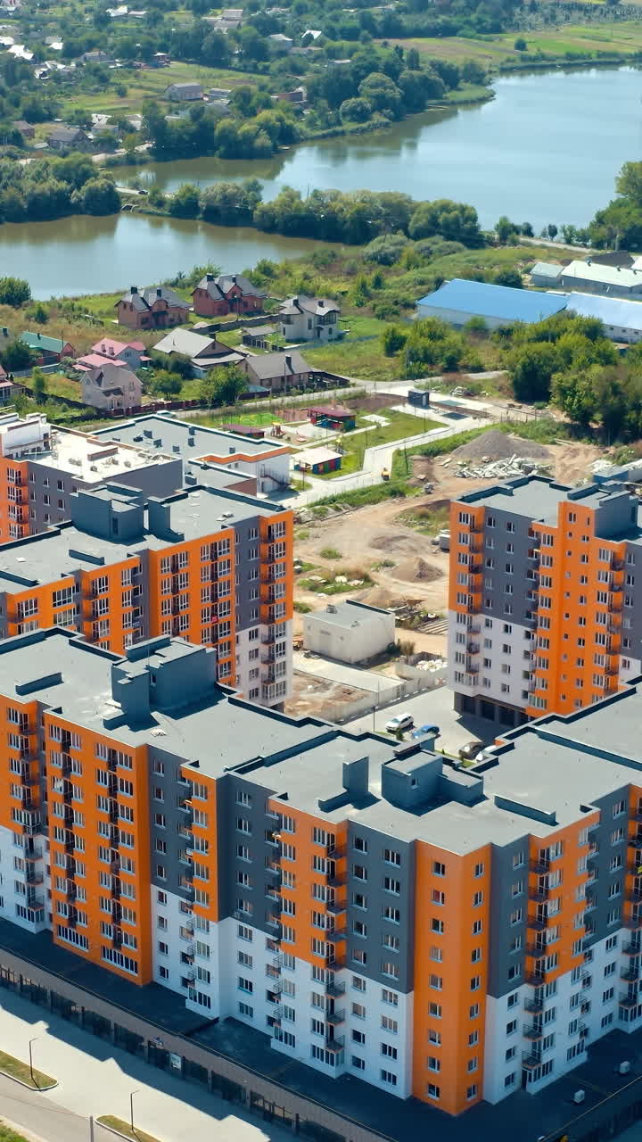 Modern urban apartment building in city. Aerial view of newly built modern apartment building facade. Vertical video