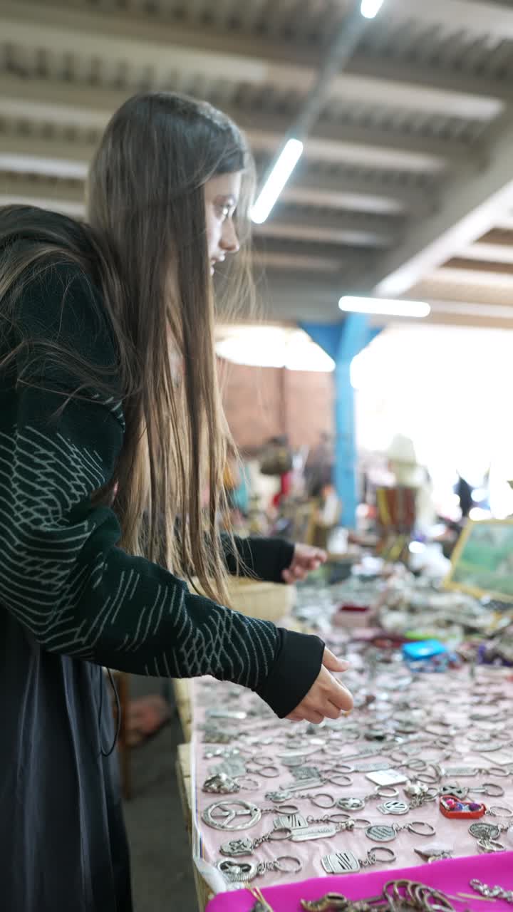 mujer revisando joyas en un mercado de pulgas