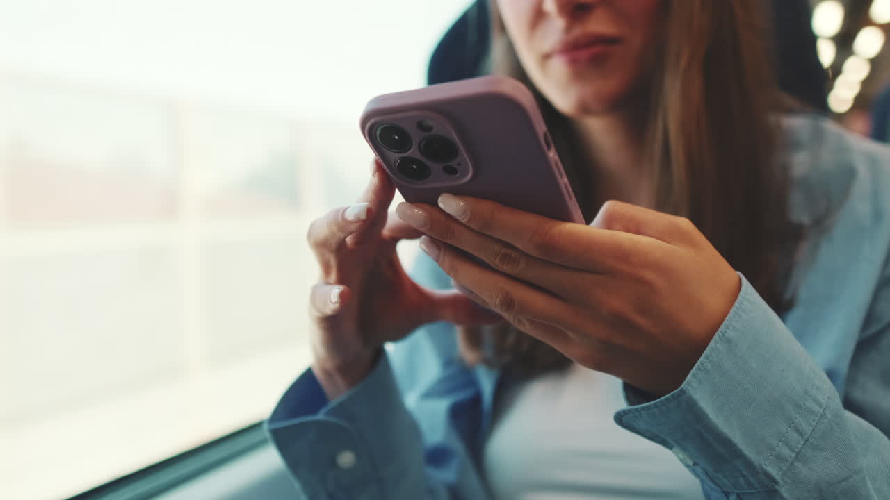 Giovane donna che usa lo smartphone mentre viaggia sui mezzi pubblici