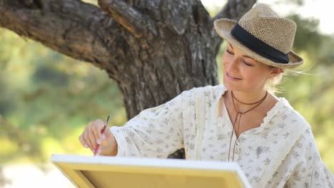 beautiful female artist painting picture in art studio