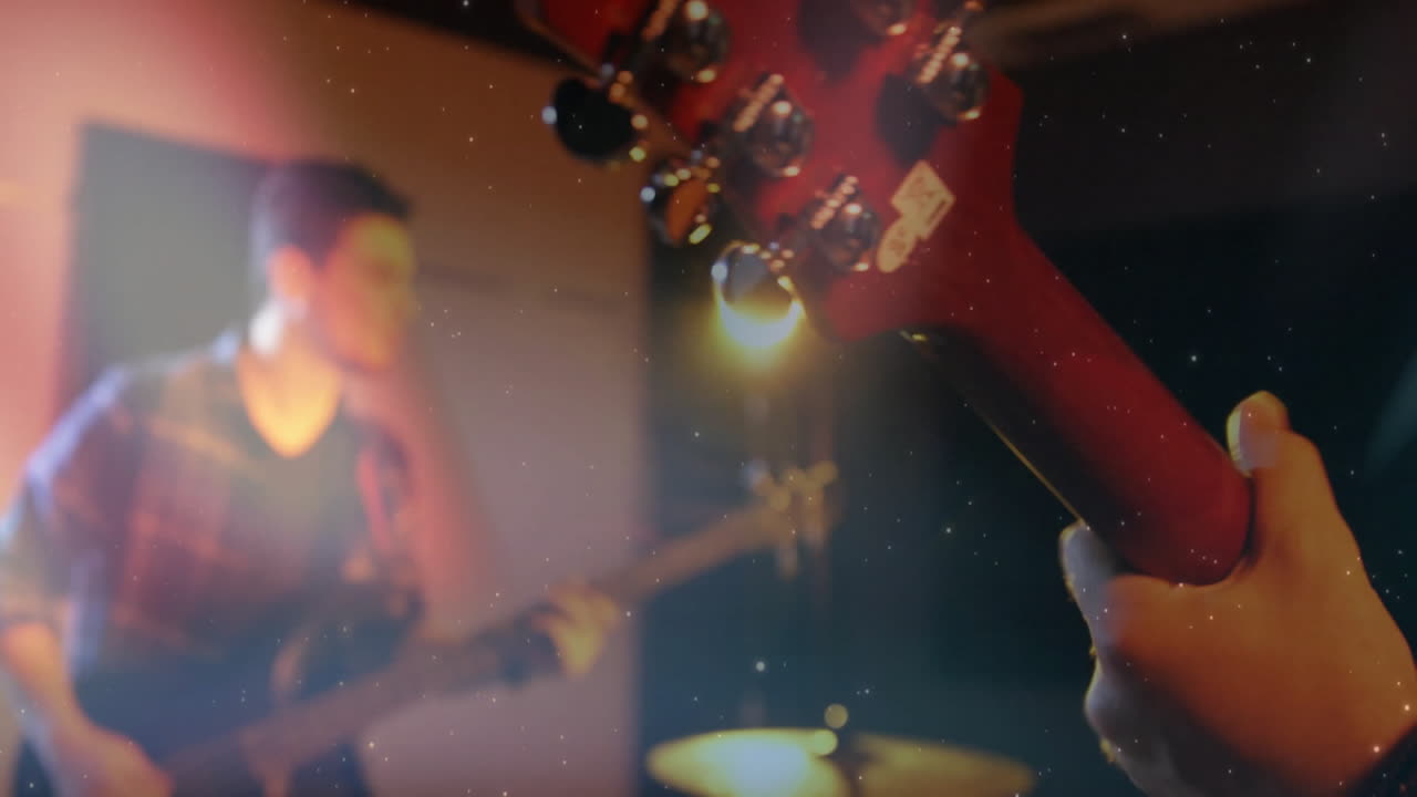 Guitarist tuning red electric guitar headstock in stage haze, with animated music production waves