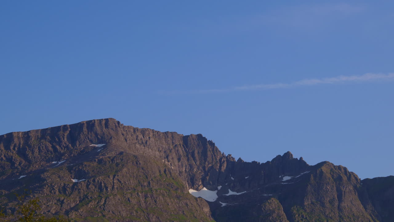 Sun hits the mountain peaks late in the evening in Sunnmøre, Norway