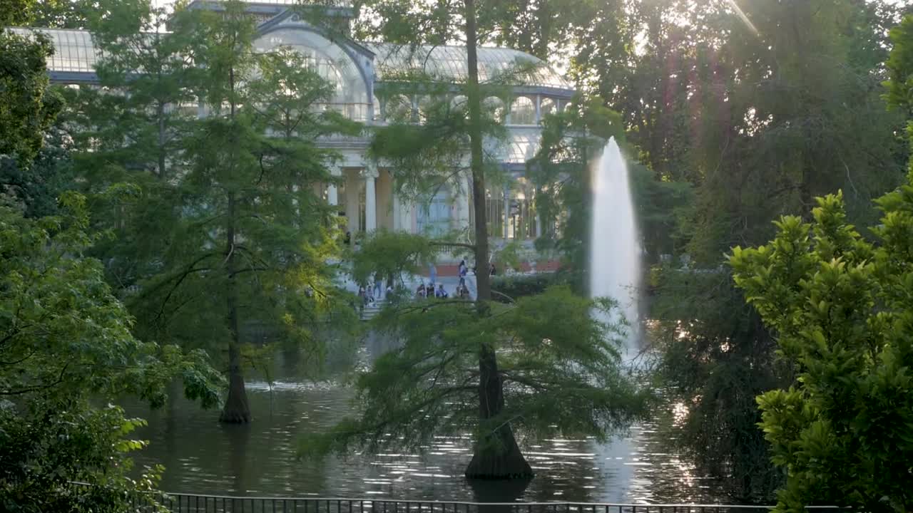 The Glass Palace pond and palace in Madrid at twilight. Beautiful and serene urban garden scene.