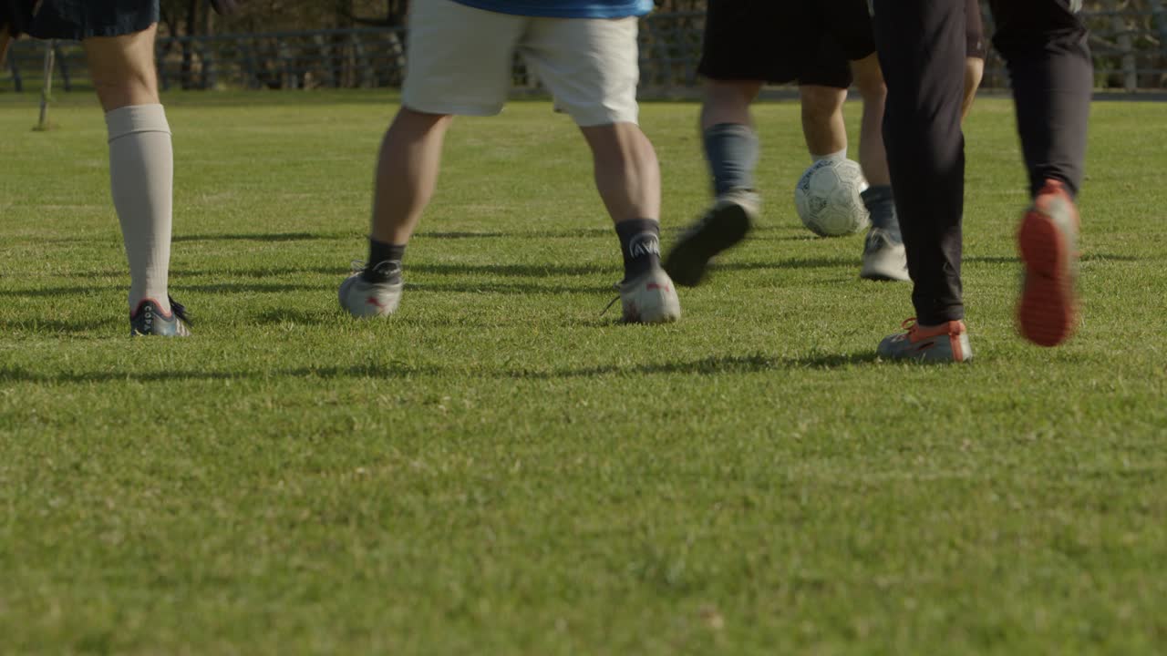 Players dribble a football soccer ball on a grassy field, focusing on footwork and movement
