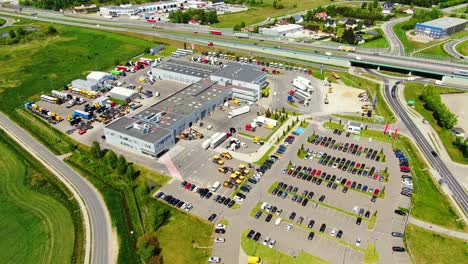 aerial top down view of the big logistics park with warehouses, loading hub and a lot of semi trucks with cargo trailers awaiting for loading unloading goods on ramps