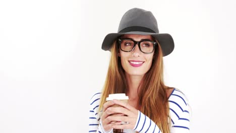 bonita morena con gafas y sombrero bebiendo café