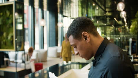 Side-view-of-african-american-receptionist-in-a-hotel