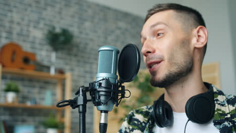 man singing into a microphone in a home studio
