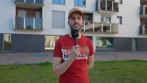 caucasian man in red shirt talks in microphone a medium shot