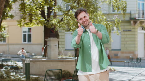 happy man tourist showing thumbs up like positive something good positive feedback on city street