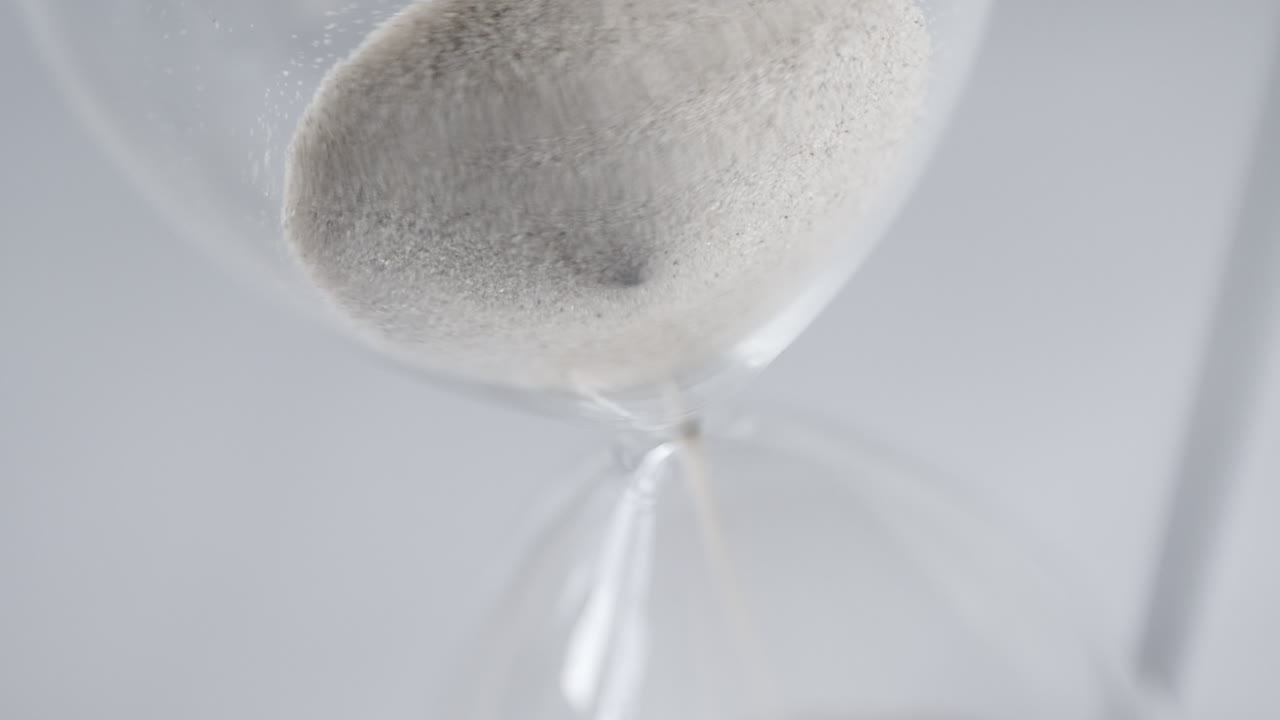 위에서 슬로우 모션으로 떨어지는 모래 시계 모래