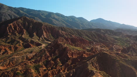 cinematic descending drone shot flying over mountain ridges at fairy tale canyon near issyk-kul lake in karakol, kyrgyzstan