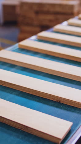 wooden boards moving on a conveyor line. modern factory of parquet production. manufacturing of furniture. vertical video