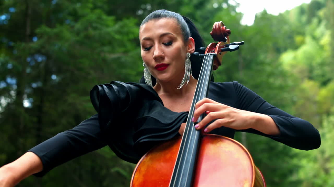 Portrait of woman playing cello. Woman performing music on cello outdoor