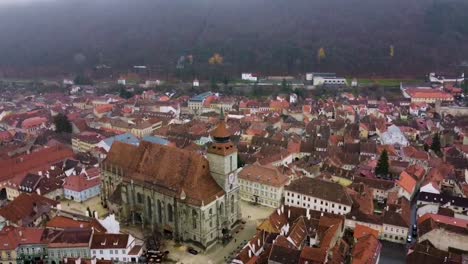 drone circles around the black church in council square of brasov during a cold winter day - romania