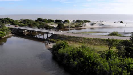 static aerial video of a bridge over the river with cars passing on a sunny day