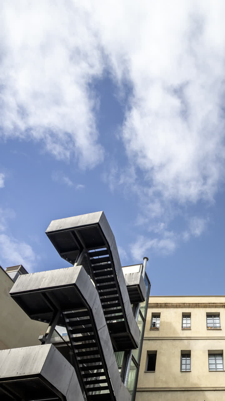 Old factory chimney and apartment buildings in barcelona in vertical