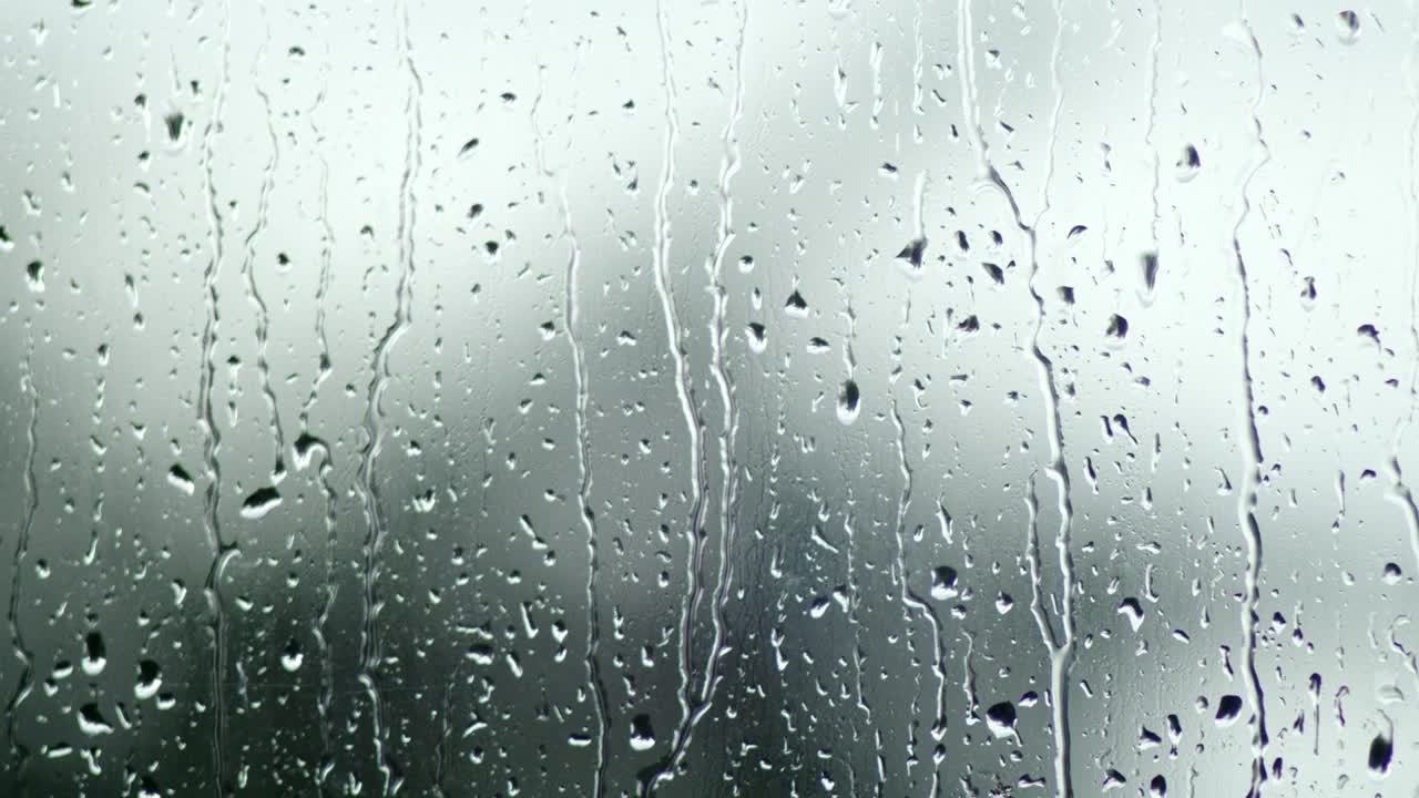 raindrops on glass, cloudy day background in blur