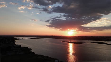 Reveal-a-brilliant-golden-sunrise-reflecting-off-Moses-Lake,-Washington,-aerial