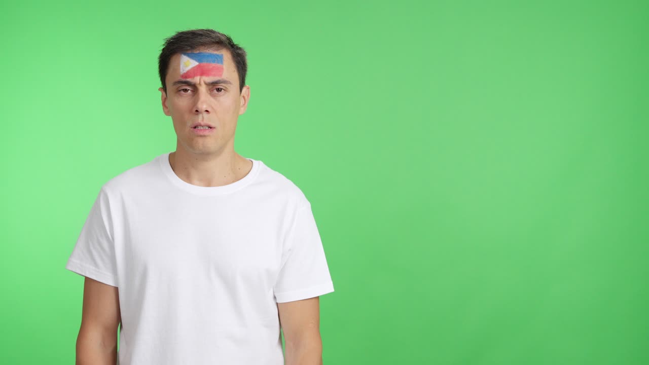 Man standing with philippine flag painted on face smiling