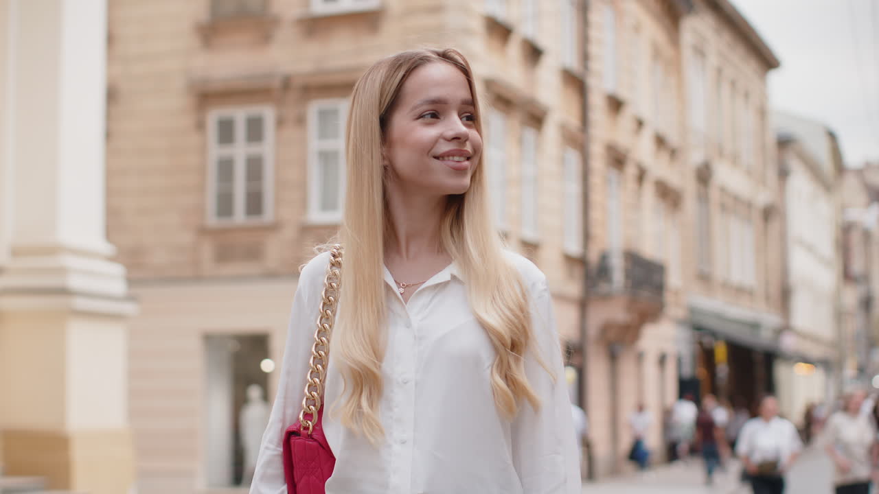 Portrait of young woman girl tourist walking in urban city street smiling having positive good mood