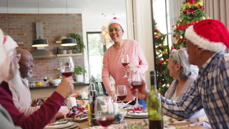 Fröhliche,-Abwechslungsreiche-Seniorin,-Die-Beim-Weihnachtsessen-Mit-Freunden-Anstößt,-Zeitlupe