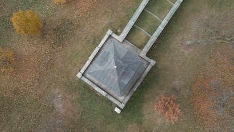 vista aérea de arriba hacia abajo de una pequeña iglesia en medio de algunos árboles de otoño