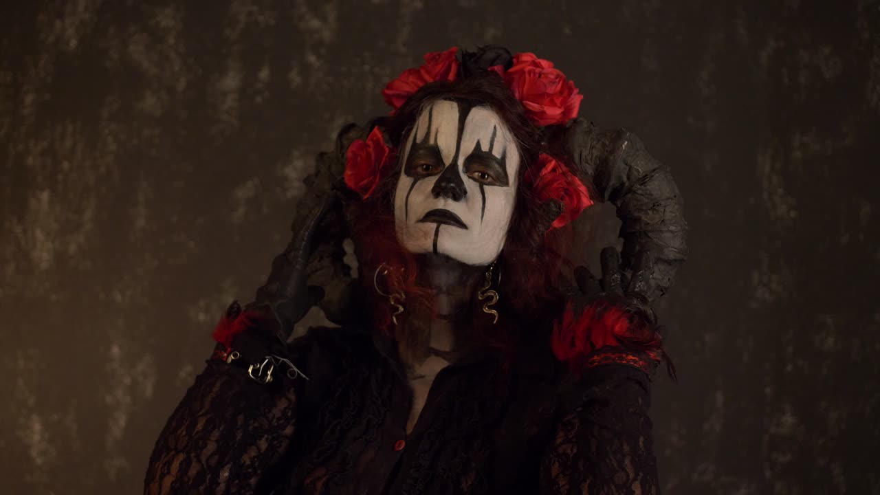 Ragazza in cosplay di Catrina che si accarezza il viso con un'espressione seducente su uno sfondo scuro, primo piano medio