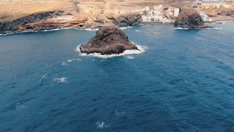 Roques-de-Fasnia,-Tenerife:-aerial-view-in-orbit-of-the-two-rock-formations-of-Fasnia-and-where-the-beach-can-be-seen