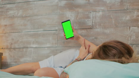 Back-view-woman-wearing-pajamas-holding-phone