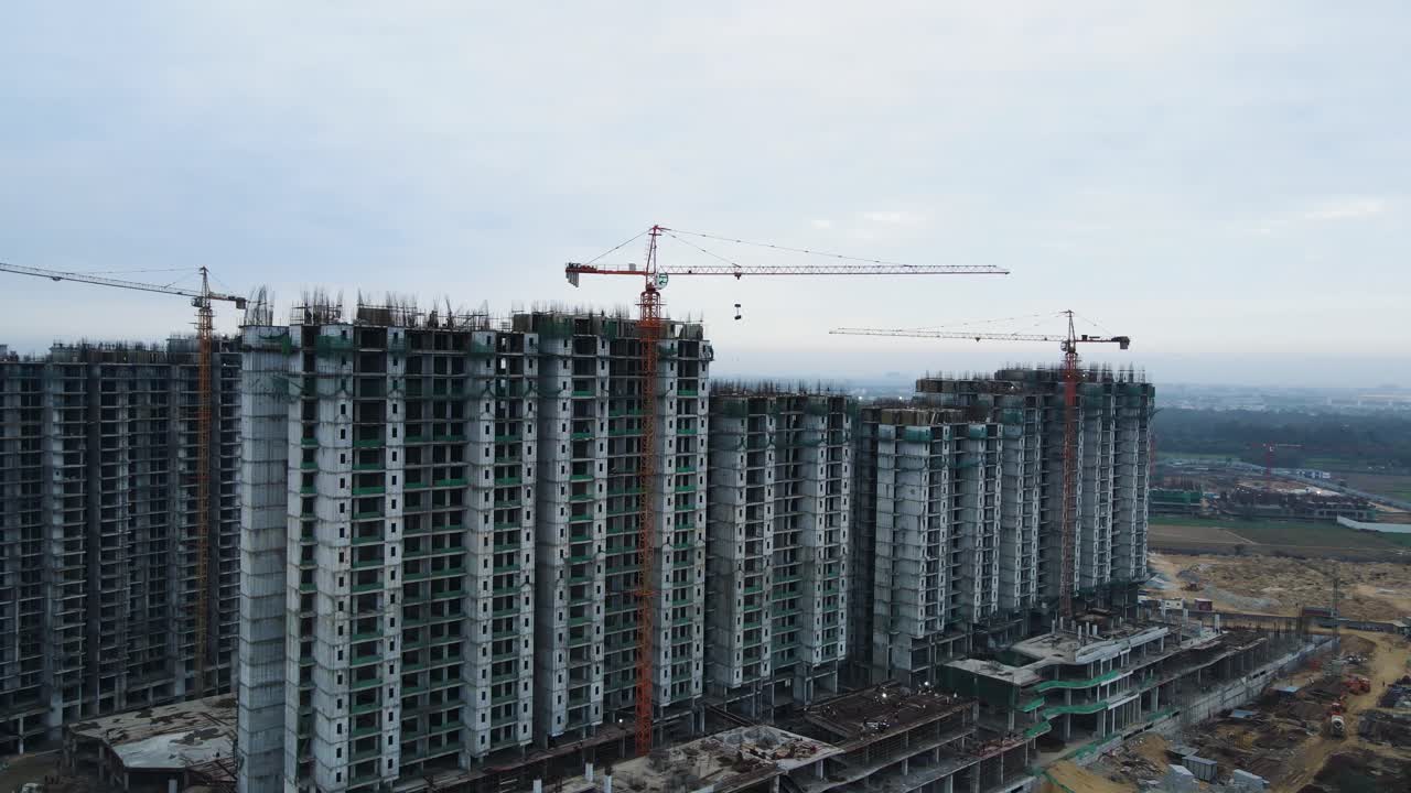 Aerial drone shot showcasing multiple construction sites near Dwarka Expressway, with half-built structures and active work zones.