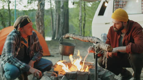 young men talking by campfire