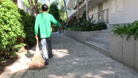 trabajador limpiando metódicamente un camino con una escoba